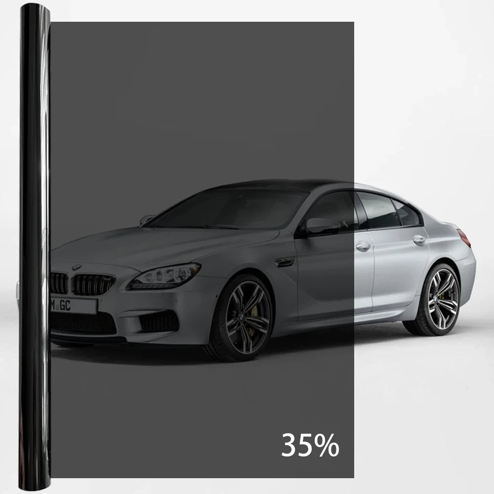A silver BMW sedan with a black privacy tint film applied to the windows.