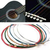 A set of six color-coded acoustic guitar strings, including red, green, blue, and yellow, laid out for display.