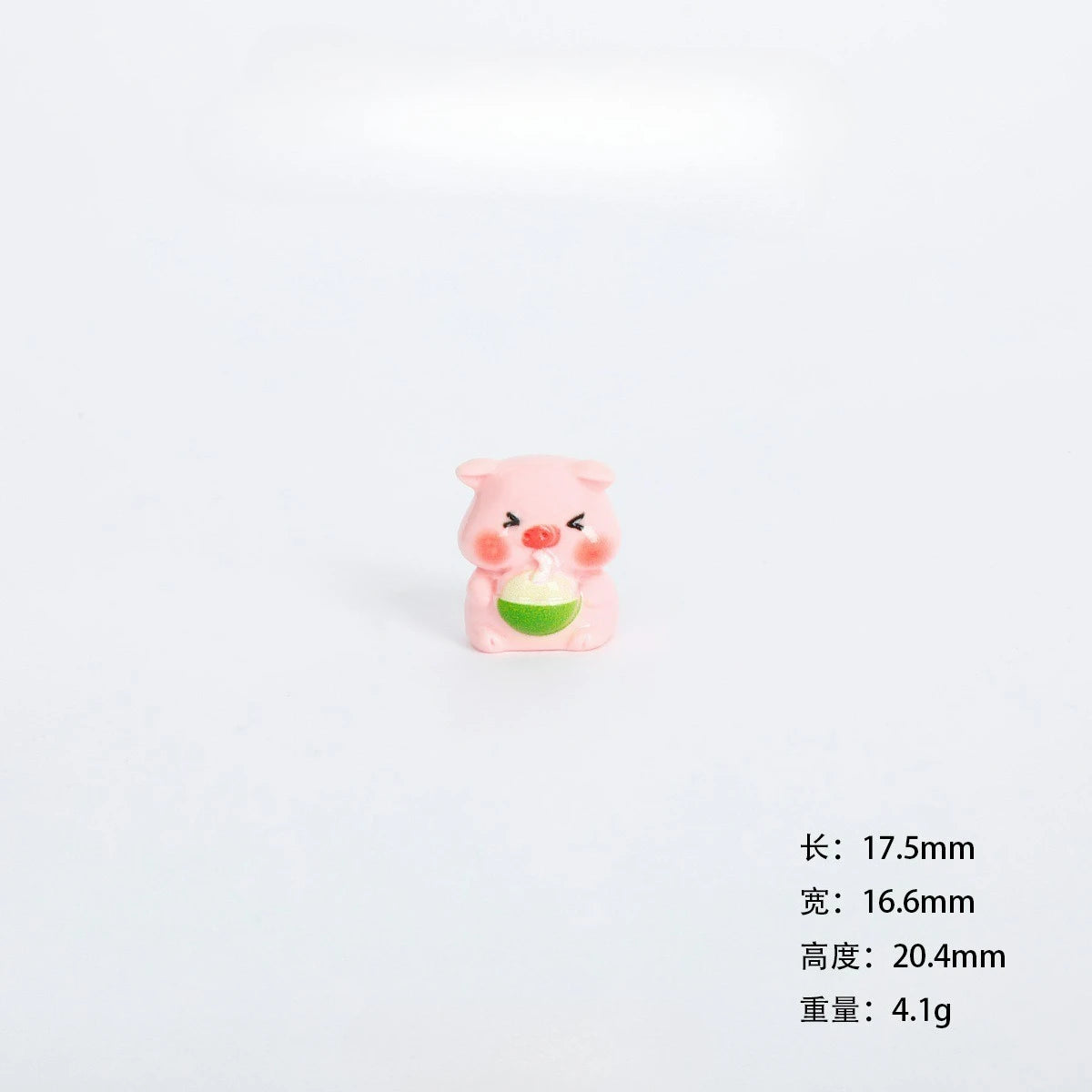 A small pink resin figurine of a pig holding a green item, used as miniature garden or desk décor.