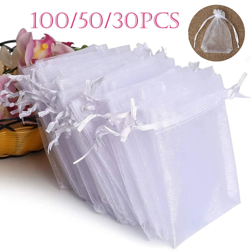 A stack of 100 white organza drawstring bags for gifts and party favors