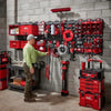A wall display of red PACKOUT magnetic bins and tools mounted on a gray concrete wall.