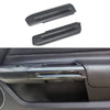 Two carbon fiber door handle covers for a Ford Mustang, shown against a dark car interior background.