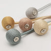 Un ensemble de tire-soleils magnétiques minimalistes en balles de différentes nuances de beige et de gris.
