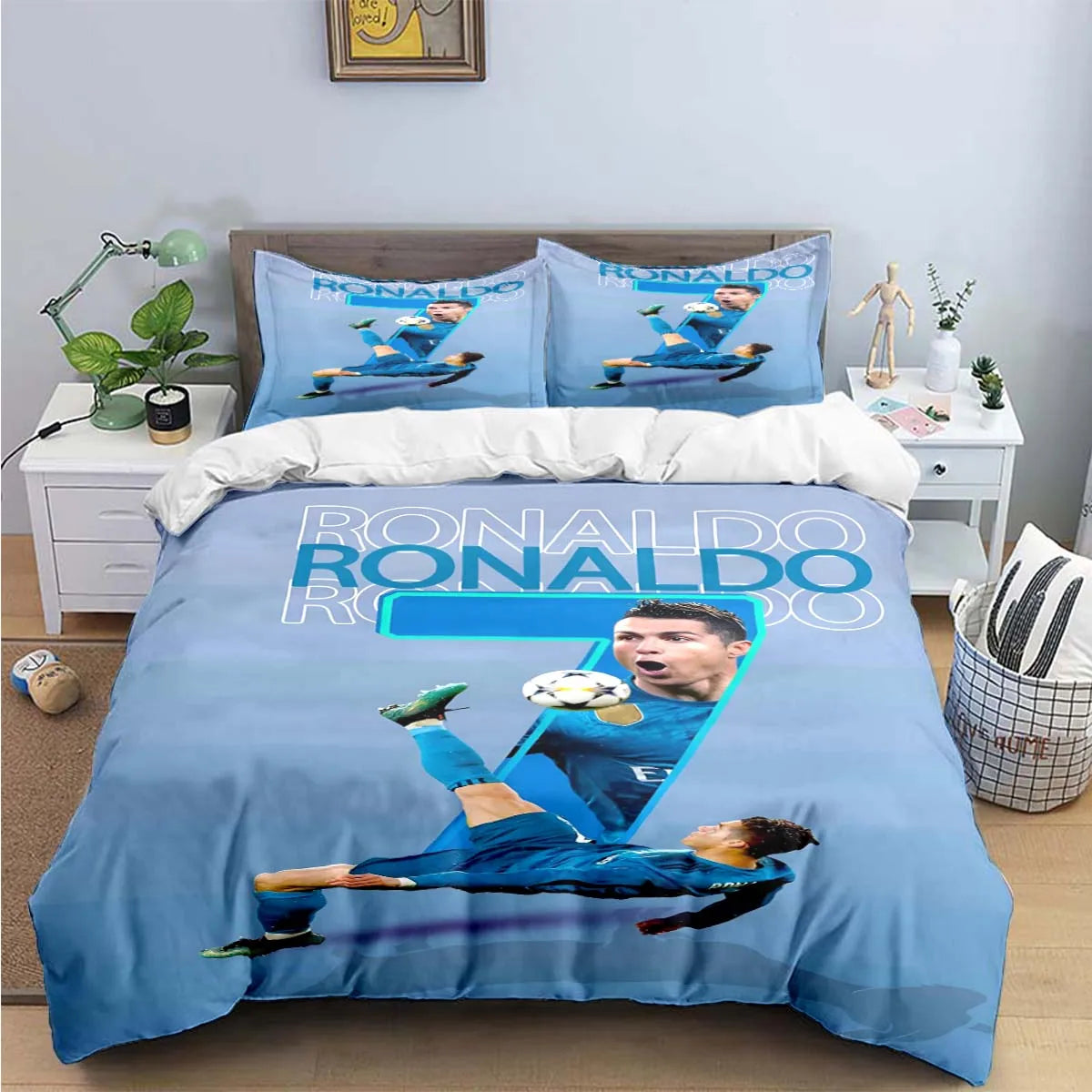 A blue soccer player graphic duvet cover set featuring Ronaldo and his likeness on a bed.