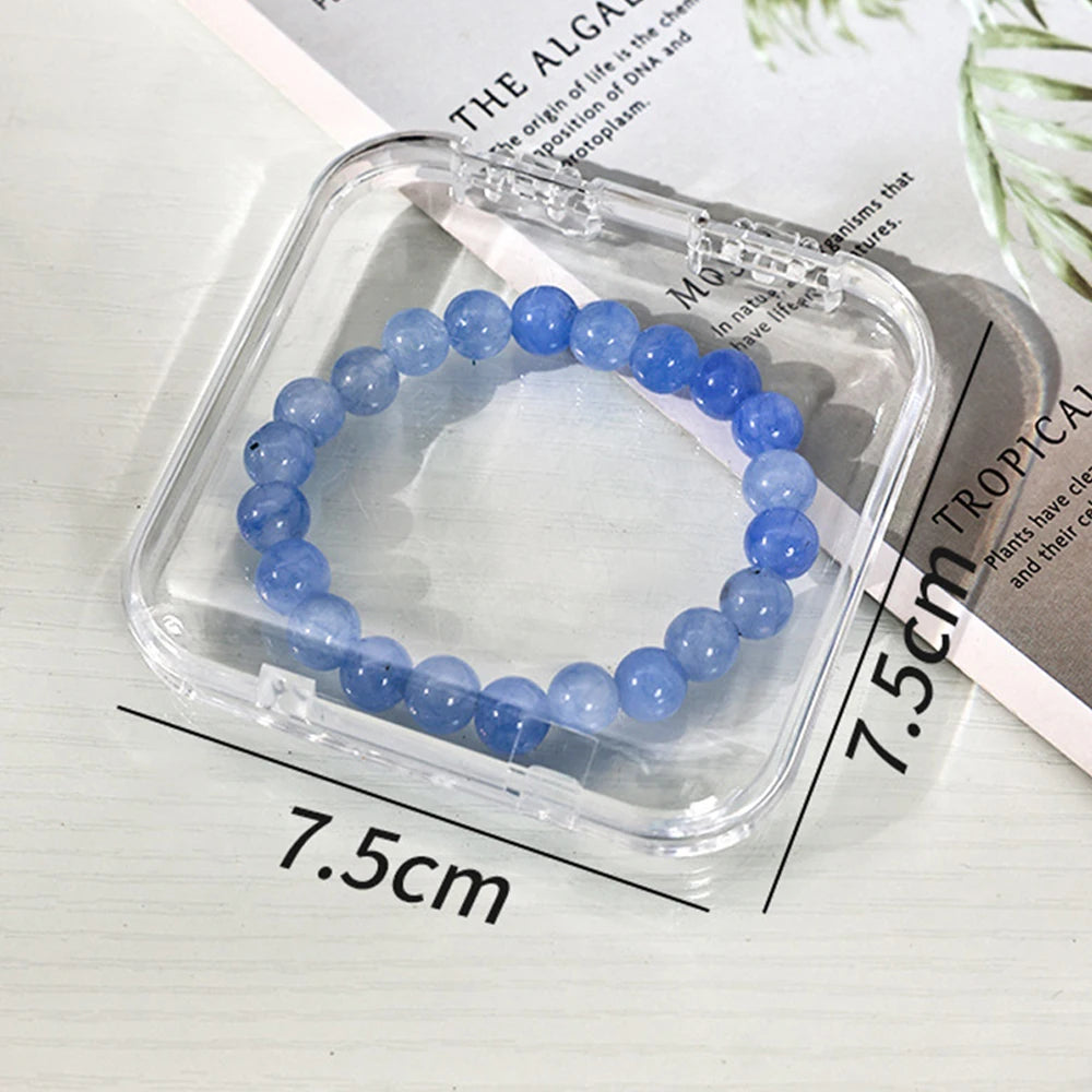 A bracelet of light blue beads is displayed inside a clear jewelry organizer box.