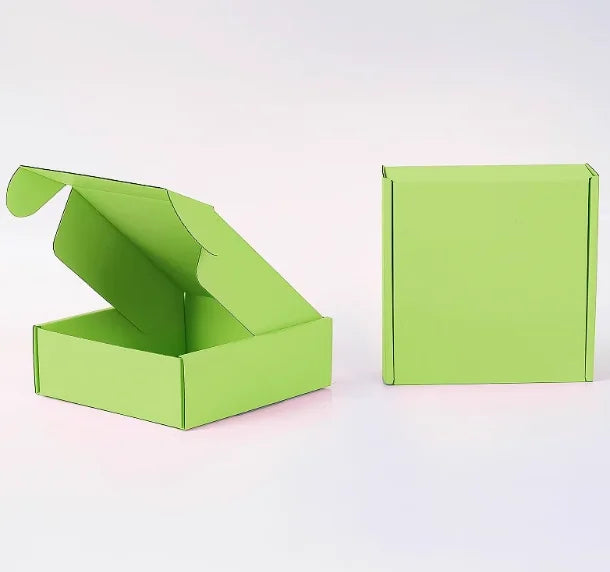 Eine limegrüne Wellpappkarton ist geöffnet und eine geschlossene Box daneben zu sehen.