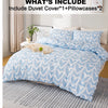 A light blue heart print duvet cover set with two pillowcases displayed on a bed with a neutral gray rug.