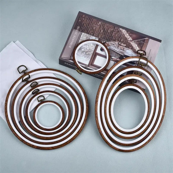 A set of wooden embroidery hoops for cross-stitch and needlework displayed next to a book.