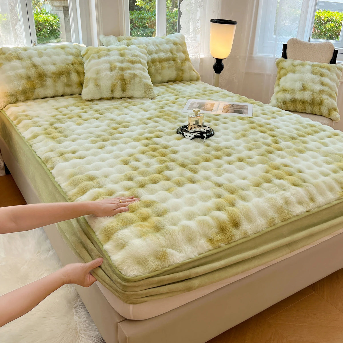 A luxury faux fur fitted sheet and pillowcase set in pale lime green color displayed on a bed.