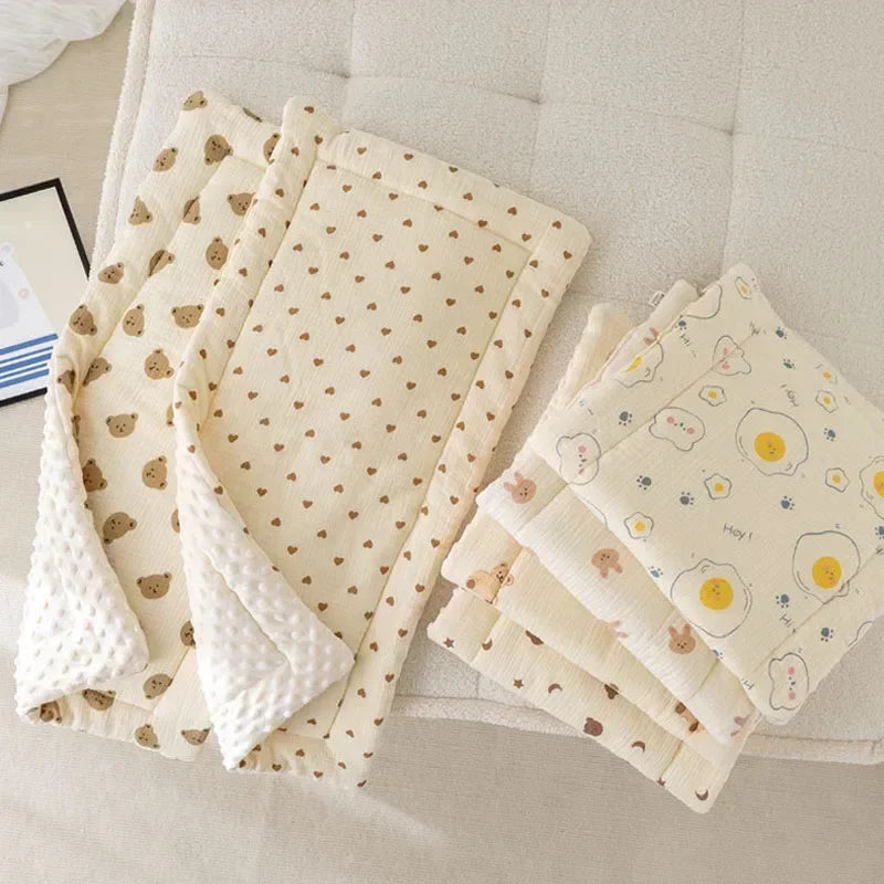 A stack of beige fabric cushions featuring a pattern of small brown bear shapes and yellow accents.