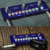 A blue M-AVE multi-effects guitar pedal with various knobs and an output jack resting on a wooden surface.