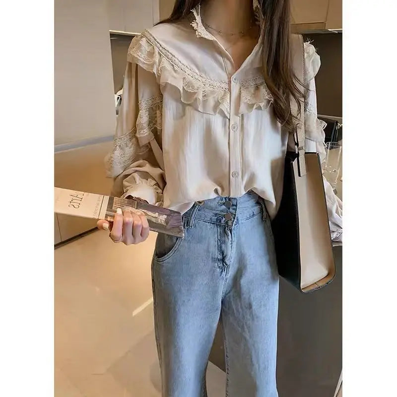 A woman models a cream vintage lace long sleeve blouse and light wash jeans in a modern setting.