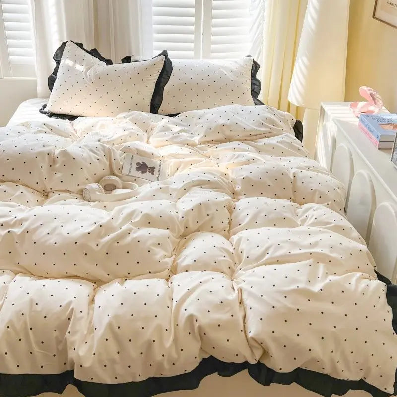 White polka dot bedding set with a duvet cover and pillows displayed on a bed.