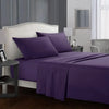 A purple bedding set with a fitted sheet, flat sheet, and pillowcases is displayed on a bed in a bedroom setting.