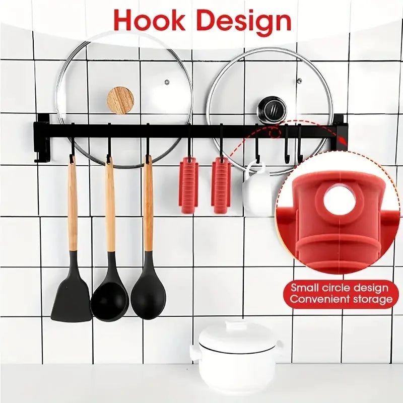 A black hook design rack displaying various silicone pan handle covers and a white pot on a tiled wall.