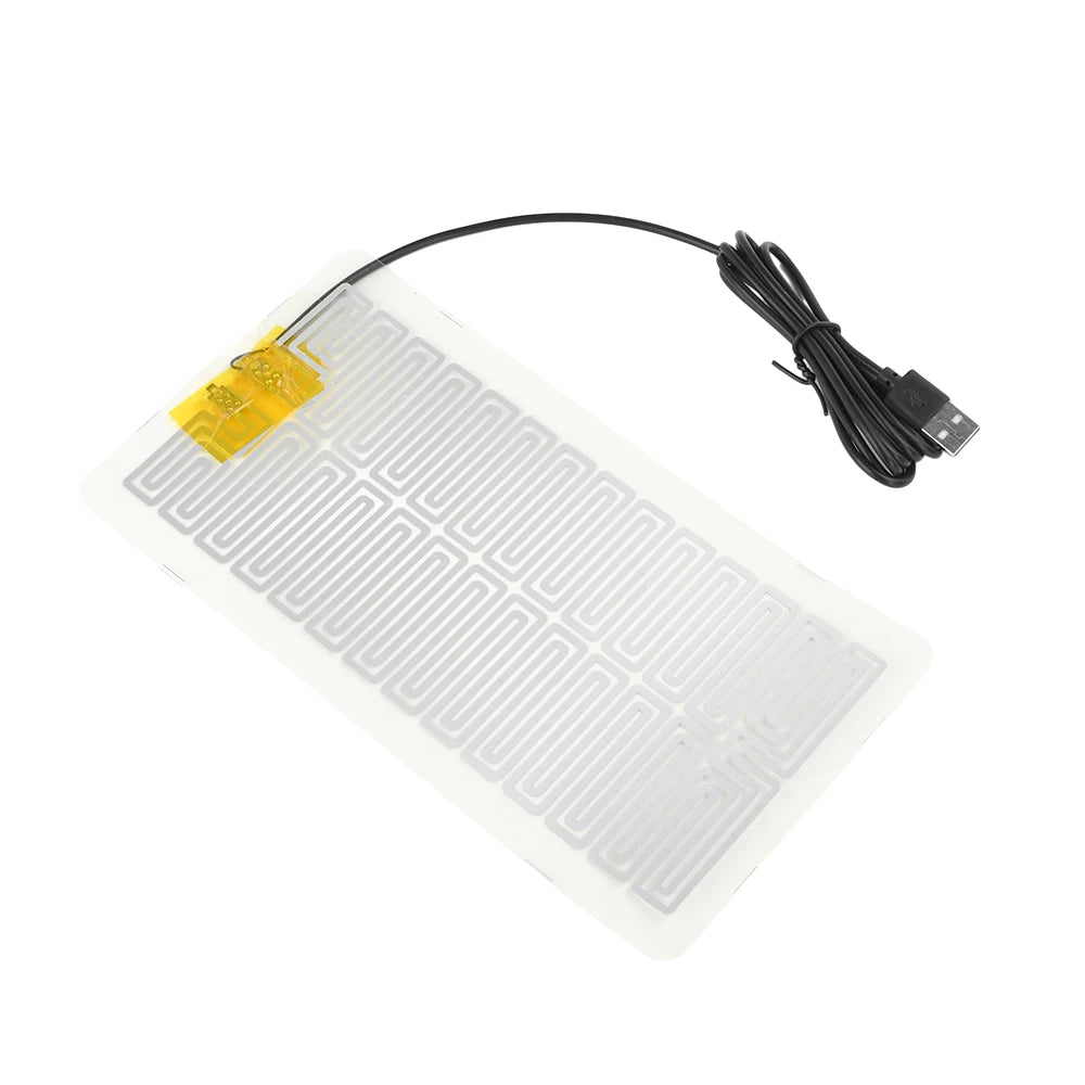 A white heating pad with a black cord and yellow tag for desk or plant warmth.
