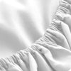 Close-up of a white fitted sheet with gathered fabric texture and deep pockets.