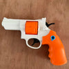 A white and orange mini mechanical revolver water gun is shown on a wooden surface.