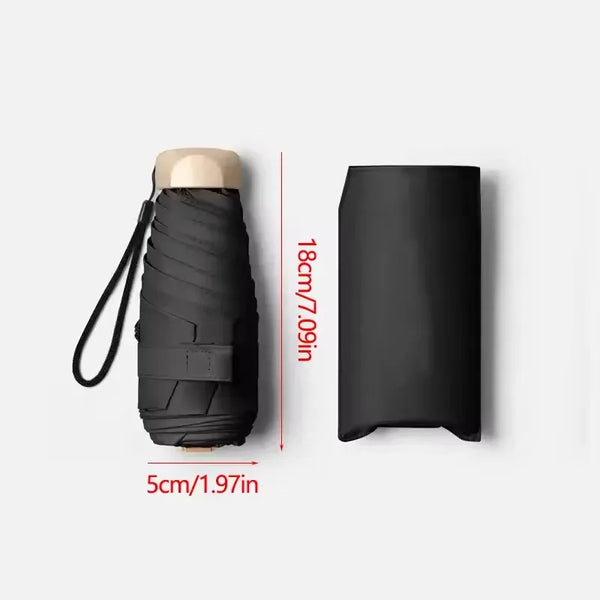 A black compact UV-protective pocket umbrella with a light-colored handle shown in a vertical view.