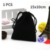 A black drawstring bag with a gold Eiffel Tower decoration and a yellow ball of yarn are shown.