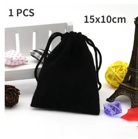 A black drawstring bag with a gold Eiffel Tower decoration and a yellow ball of yarn are shown.