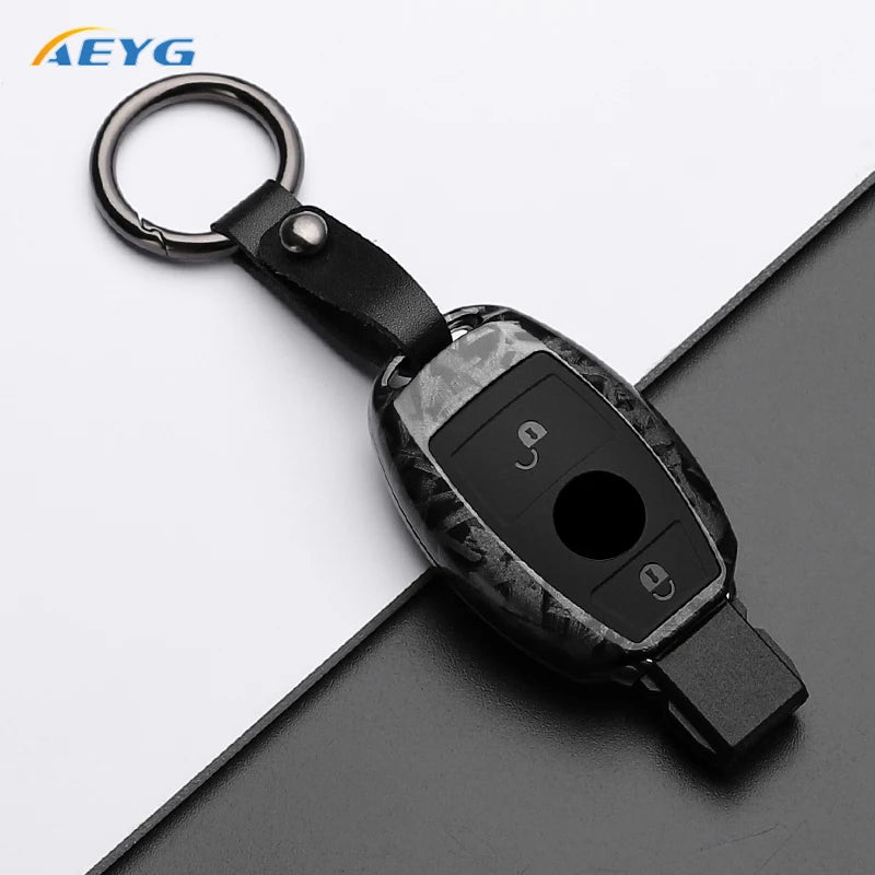 A black slim carbon fiber car key cover with a metal keyring attached.