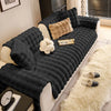 A dark gray plush anti-slip sofa cushion cover with a light beige throw and decorative pillows.