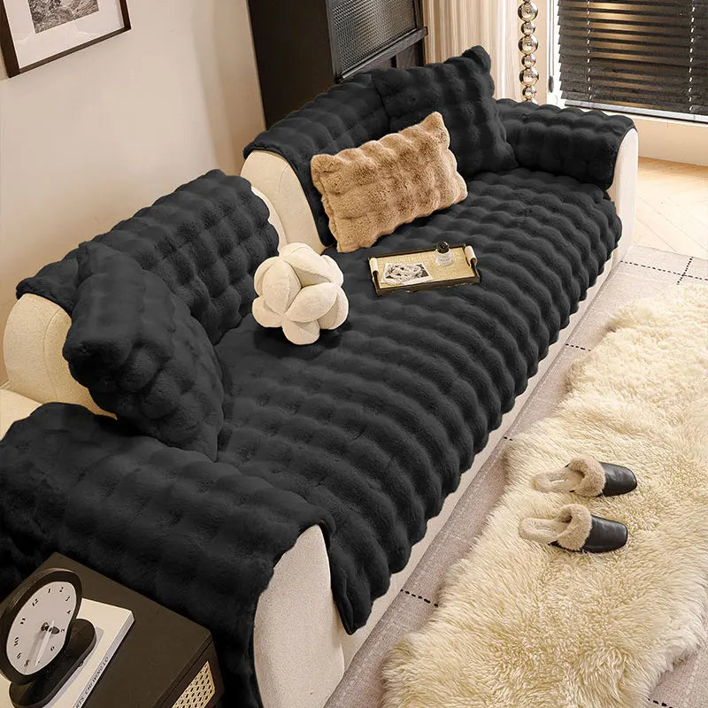 A dark gray plush anti-slip sofa cushion cover with a light beige throw and decorative pillows.
