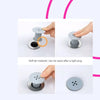 A hand is shown installing a flexible hair catcher drain cover onto a sink or tub.