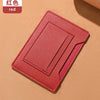 A red ultra-thin passport holder with card slots lying on a beige surface.