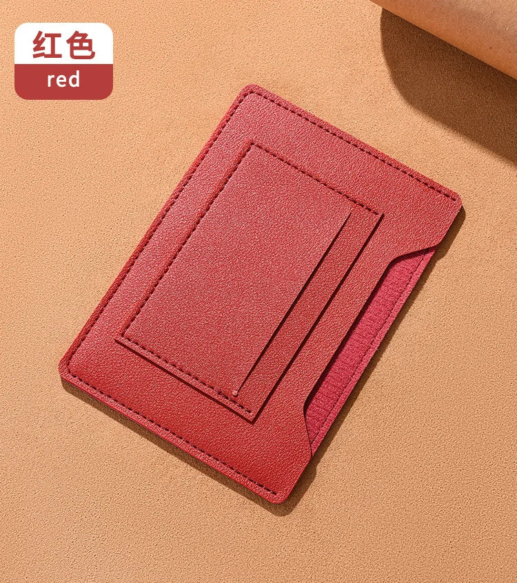 A red ultra-thin passport holder with card slots lying on a beige surface.