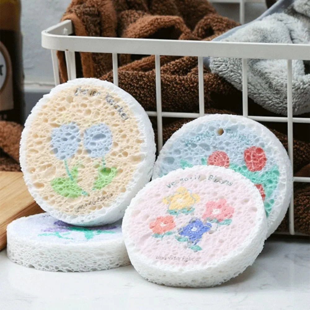 A white sponge product with floral designs is shown next to a basket of brown cleaning cloths.