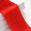 A long, bright red beaded thread curtain hanging down next to a white box.