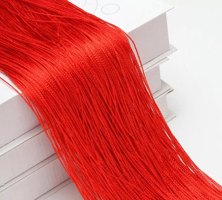 A long, bright red beaded thread curtain hanging down next to a white box.