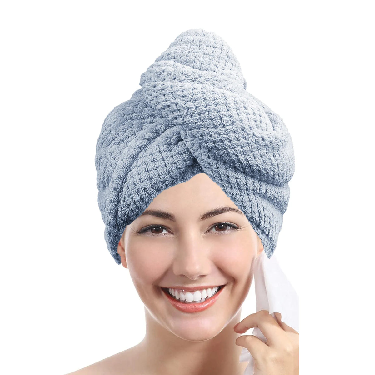 A woman is smiling while using a light blue microfiber hair towel wrap on her face.
