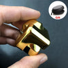 A hand holds a gold-colored alloy metal fidget cube spinner, with a black gift box visible in the upper right corner.