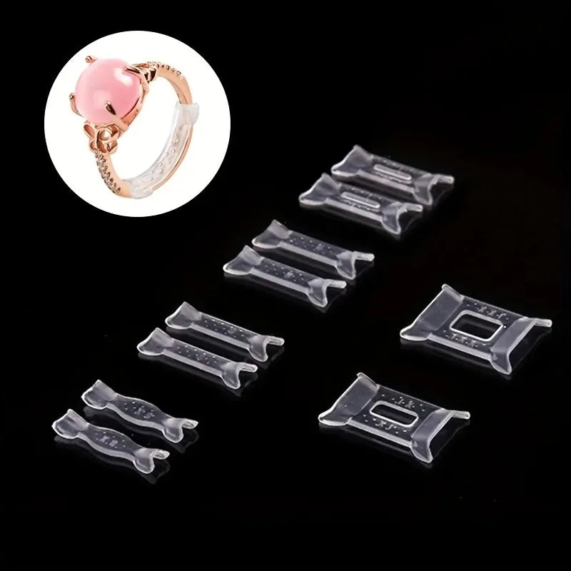 A set of twelve clear plastic invisible ring size adjuster pads and a pink ring are shown on a black background.