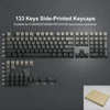 Ein Set von 133 seitlich gedruckten PBT-Keycaps für mechanische Tastaturen, gezeigt in verschiedenen Layouts und als losem Se