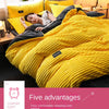 A bright yellow plush corduroy duvet cover set is displayed on a bed, featuring ribbed texture and a black accent.
