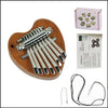 A wooden kalimba thumb piano with eight metal keys and a black cord, shown next to its packaging.