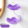 A purple lotus-shaped two-tier bathroom storage rack with drainage features mounted on a white tiled wall.