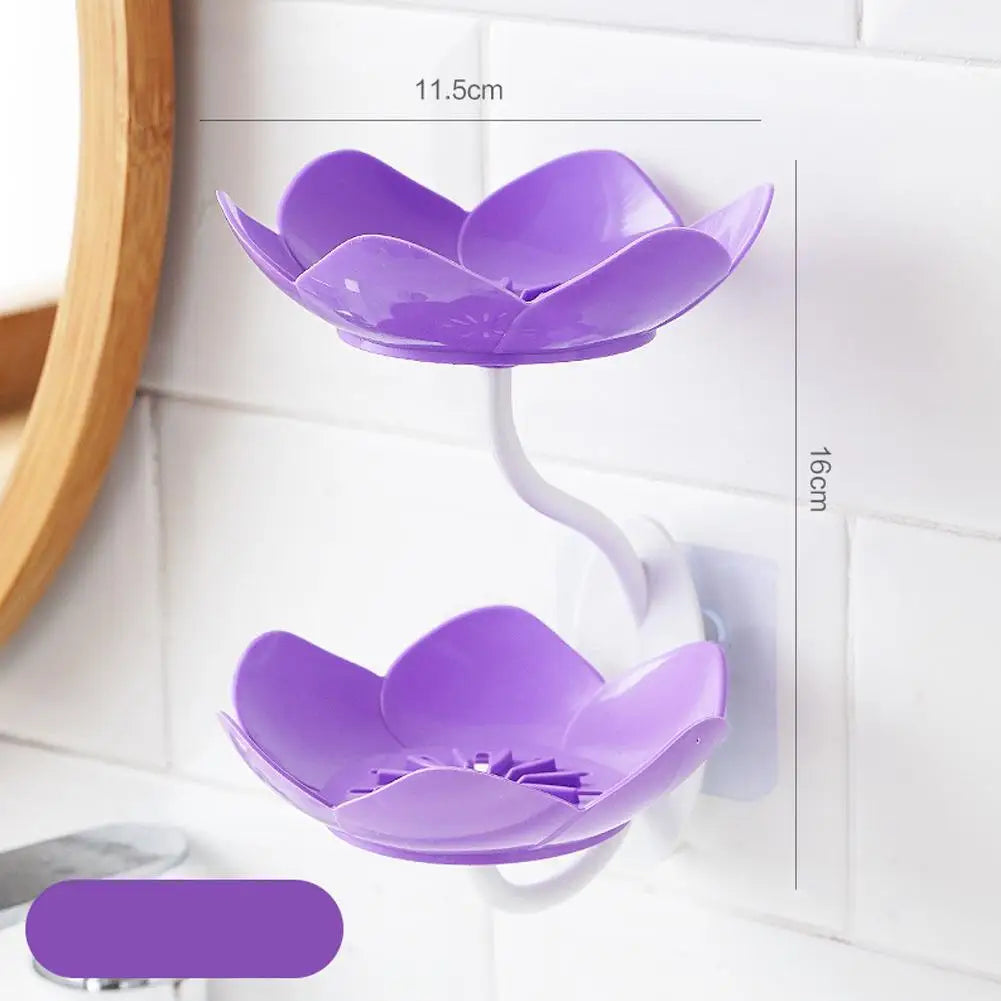 A purple lotus-shaped two-tier bathroom storage rack with drainage features mounted on a white tiled wall.