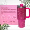 A pink rhinestone studded tumbler with a straw and handle is shown against a light background.