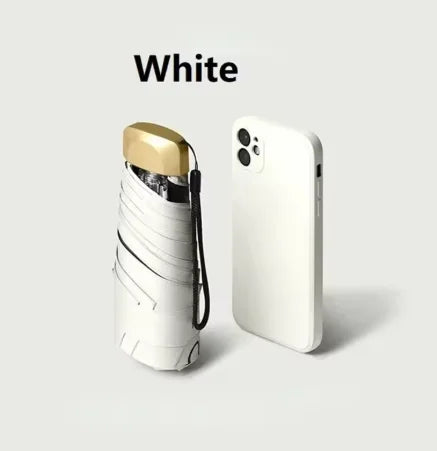 A white pocket-size folding umbrella with a gold accent is shown against a light gray background.