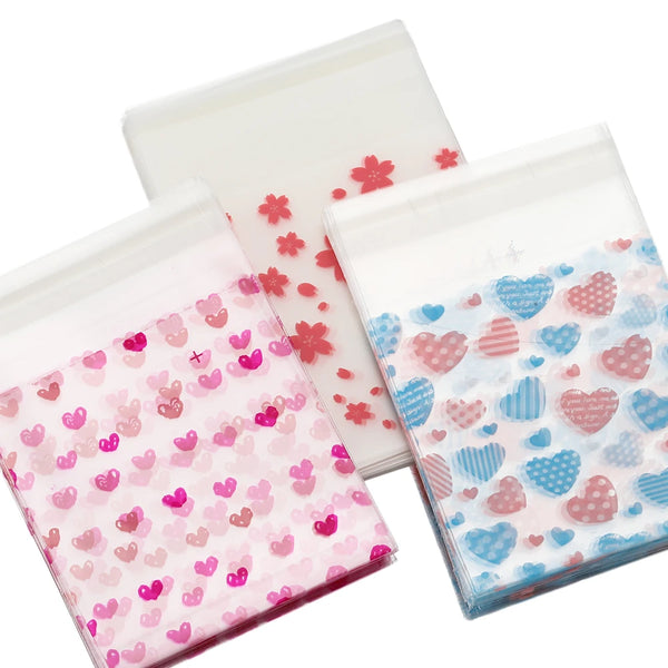 A collection of clear self-adhesive treat bags featuring various pink and blue heart patterns for Valentine's Day
