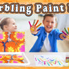 A boy and a girl are painting on paper using a marbling paint kit, showing colorful fluid art techniques.