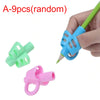 A set of random pencil grips including a blue 3-finger grip, a green 2-finger grip, and a pink ring grip being held by a hand