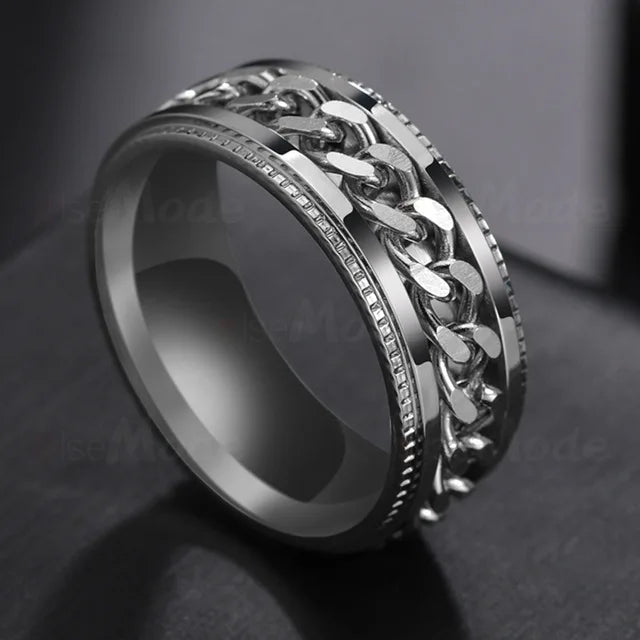 A close-up shot of a silver stainless steel spinner ring with a textured link design.