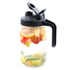 A clear glass mason jar with a black lid featuring a pour spout and handle, filled with sliced fruit.