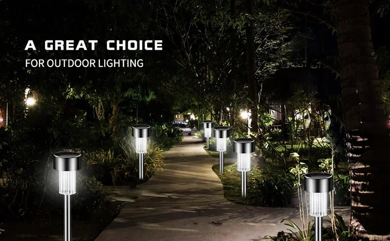 Outdoor lighting featuring modern solar powered garden lantern lights illuminating a pathway in a wooded area.